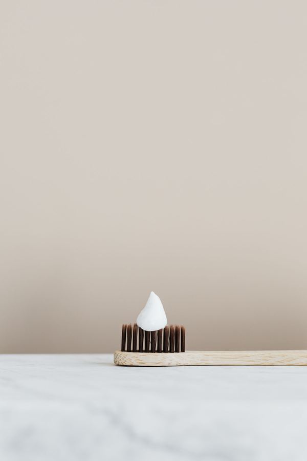 Wooden toothbrush with toothpaste on a marble surface